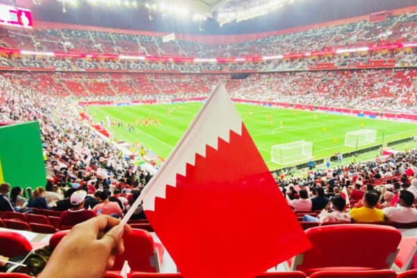 A scene during the FIFA Arab Cup where an enthusiastic fan waves the Qatari flag