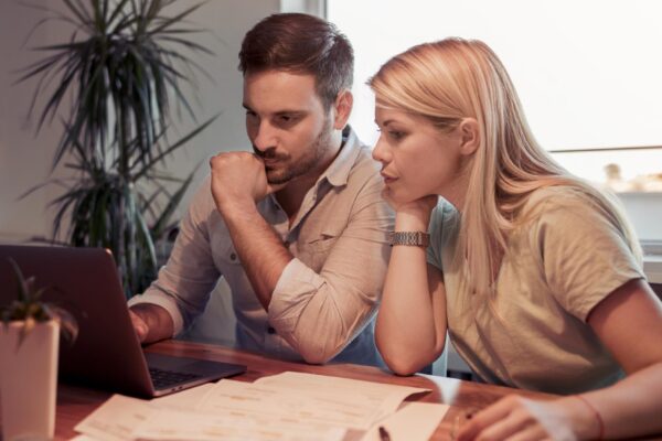 Couple checking their bills in living room at home
