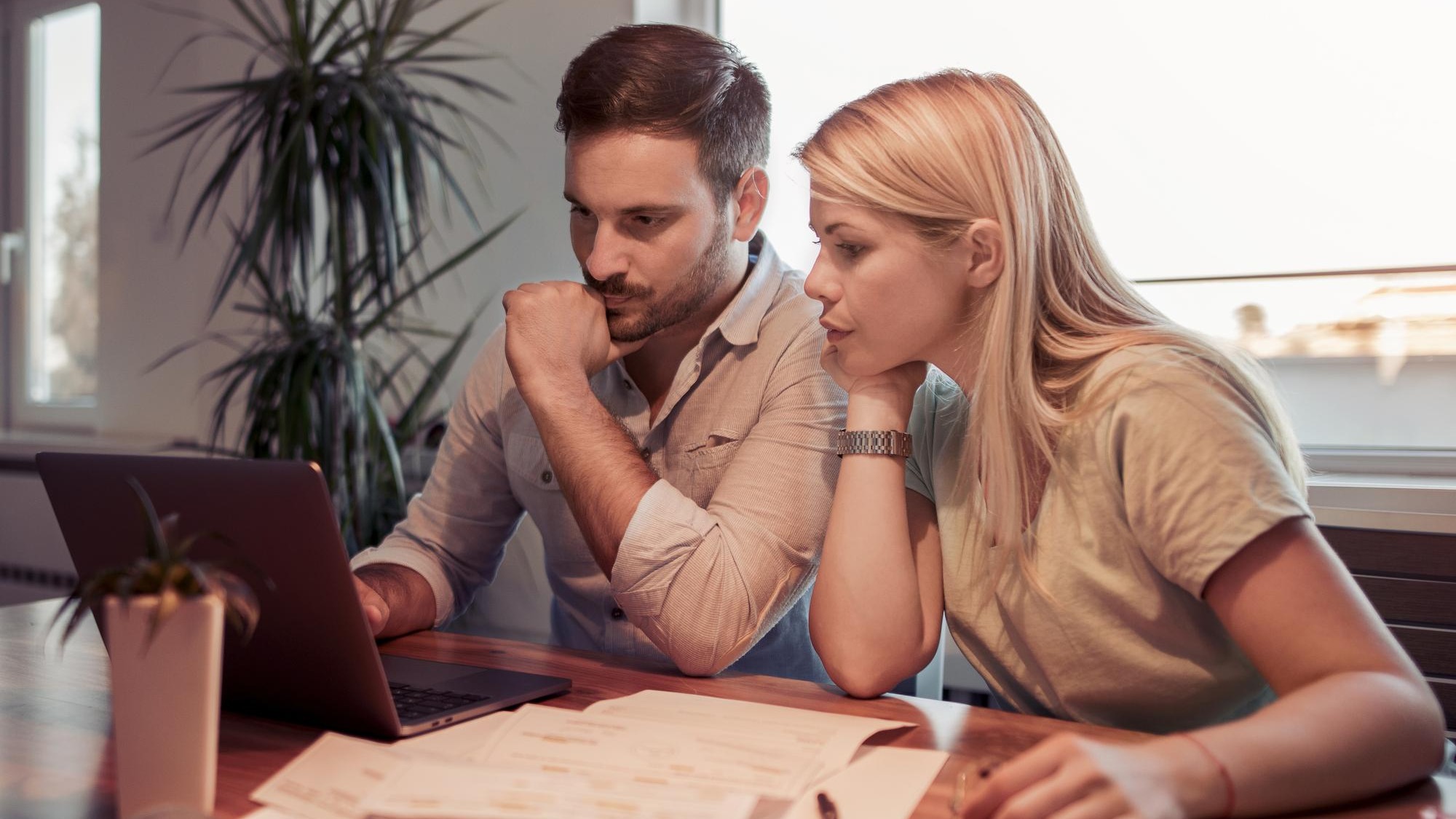 Couple checking their bills in living room at home