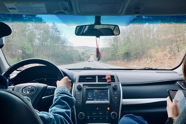 person in blue denim jeans driving car