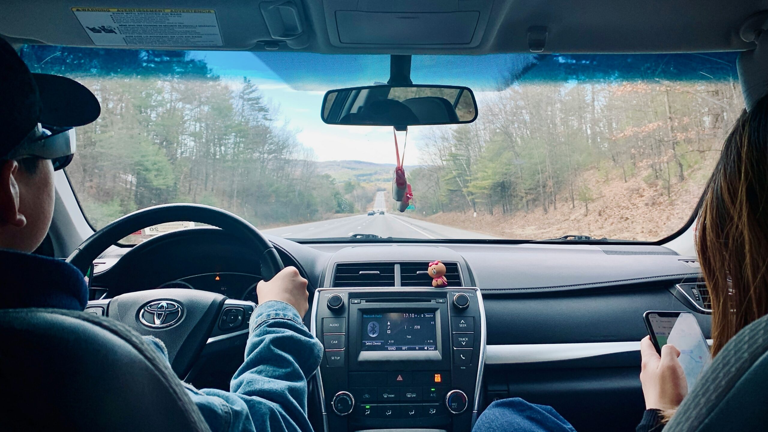 person in blue denim jeans driving car