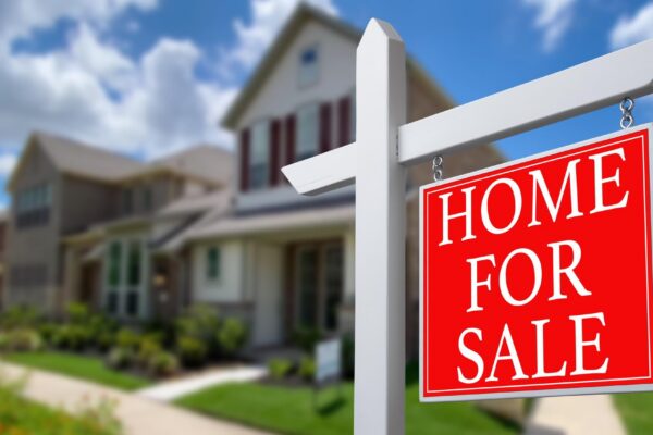 Home For Sale Real Estate Sign and Beautiful New House