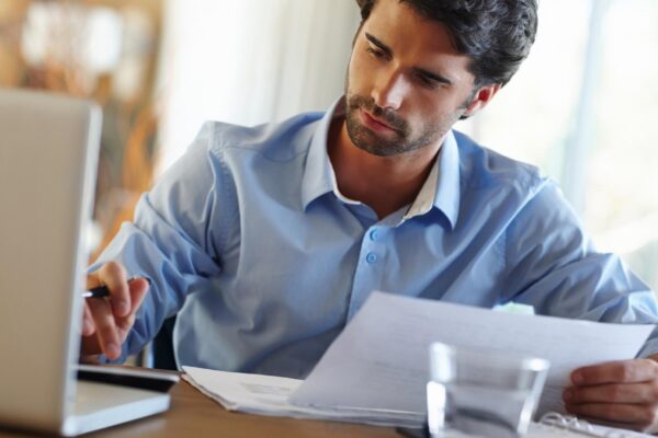 Man laptop and calculate in home office for budget planning and savings account for personal debt Male person computer and bills for audit with expenses tax and loan payment in living space