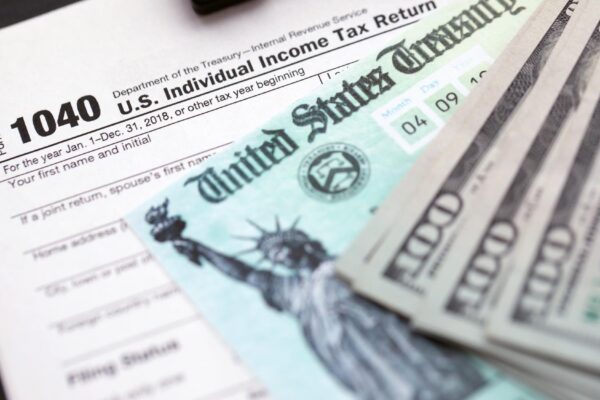 United states tax form individual income tax return with refund check and us dollar bills close up