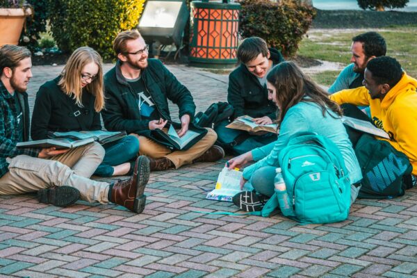 group of people sitting on pave blocks