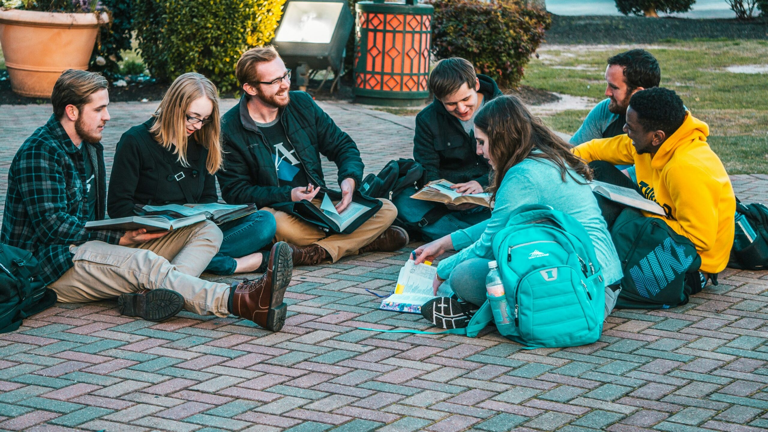 group of people sitting on pave blocks
