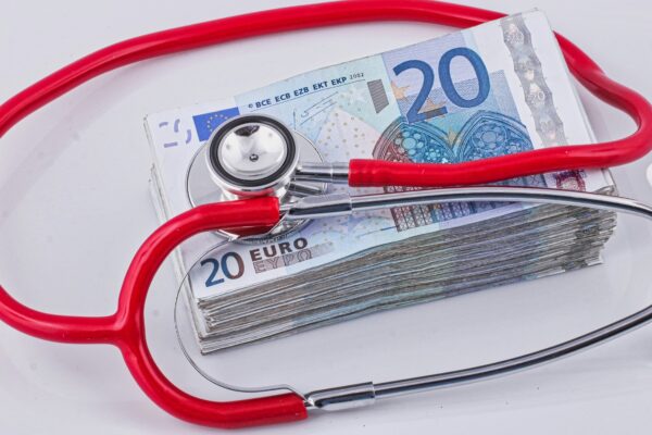 a red stethoscope sitting on top of a pile of money