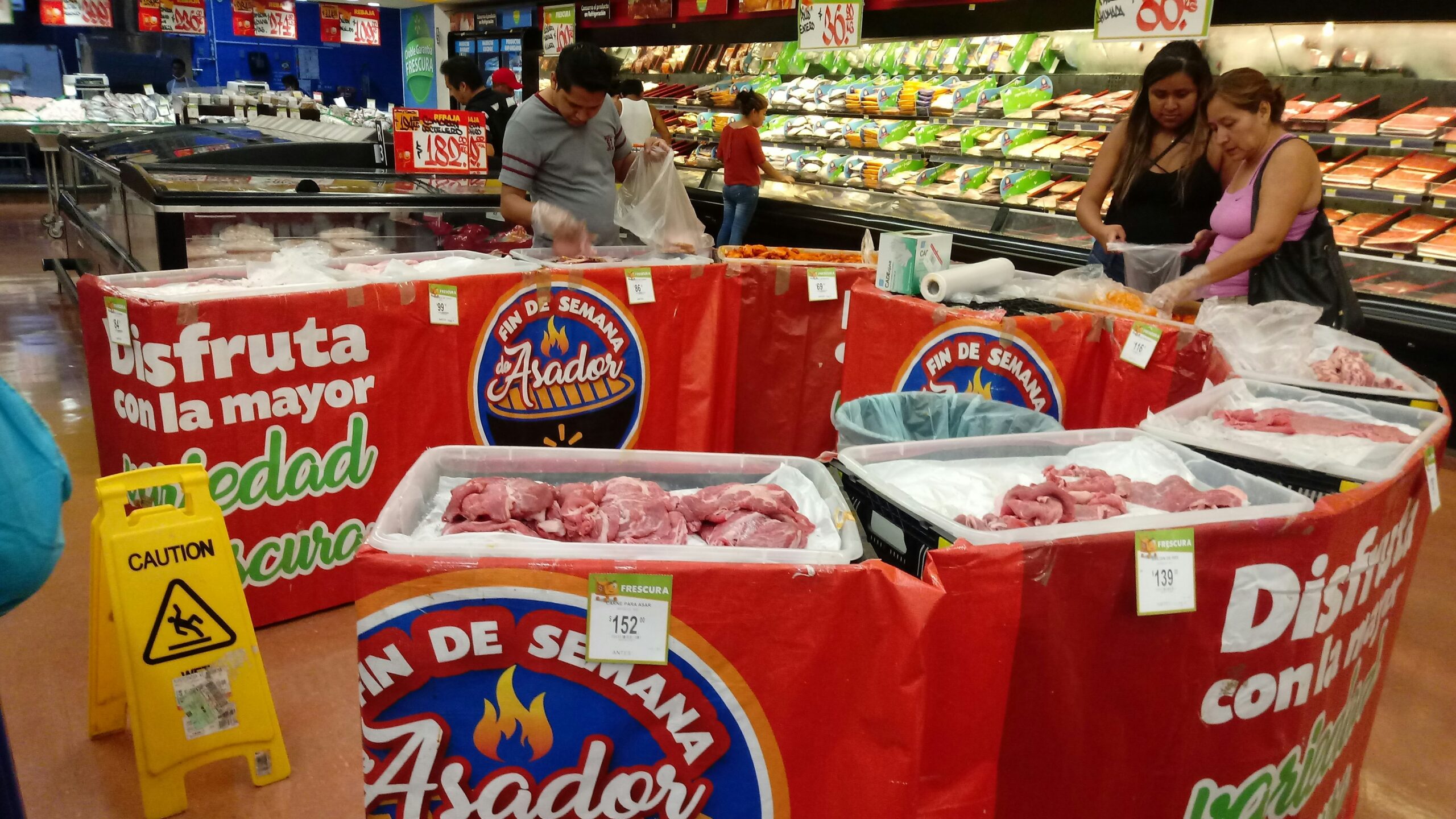people standing beside raw meats in side market
