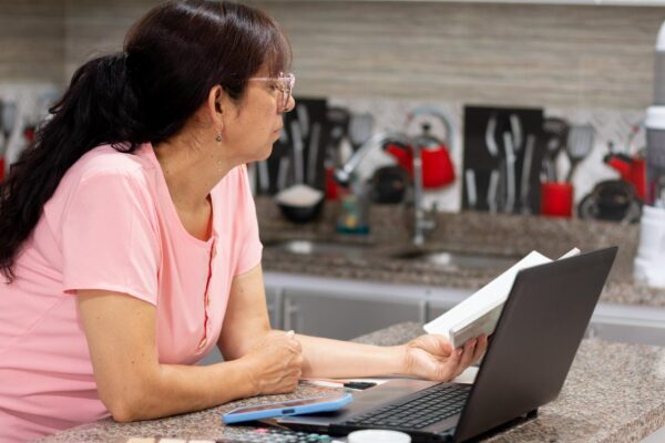 Reviewing finances Mature woman concentrating on the ledger for taxes