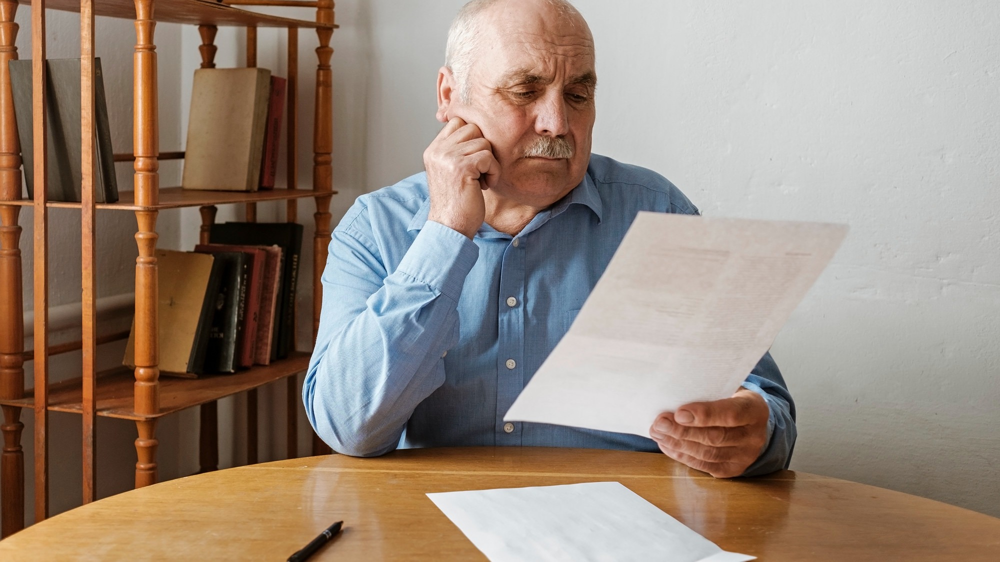 Elderly grey haired man with mustache reading