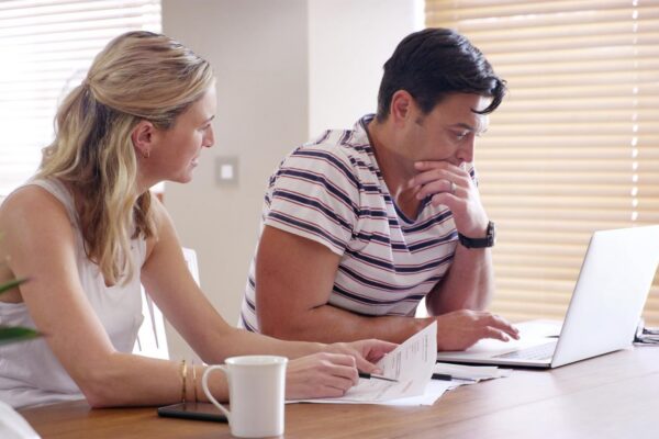 Finance trouble and couple with laptop with bills stress and internet banking issue in debt Home payment due and anxiety from mortgage tax audit or invoice with conversation about savings