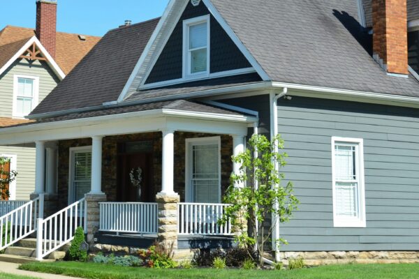 A blue house with a white porch and red chimney.