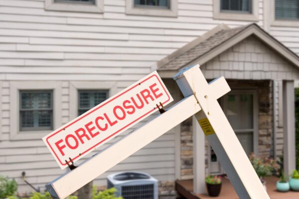 Mockup of a foreclosure sign in front of a modern townhome or townhouse to illustrate recession fears due to coronavirus