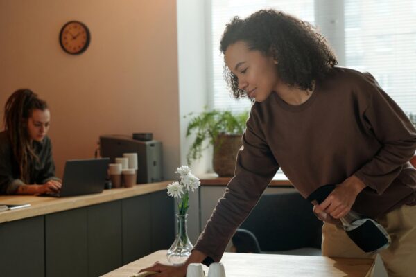 Cafe owner wiping table with duster