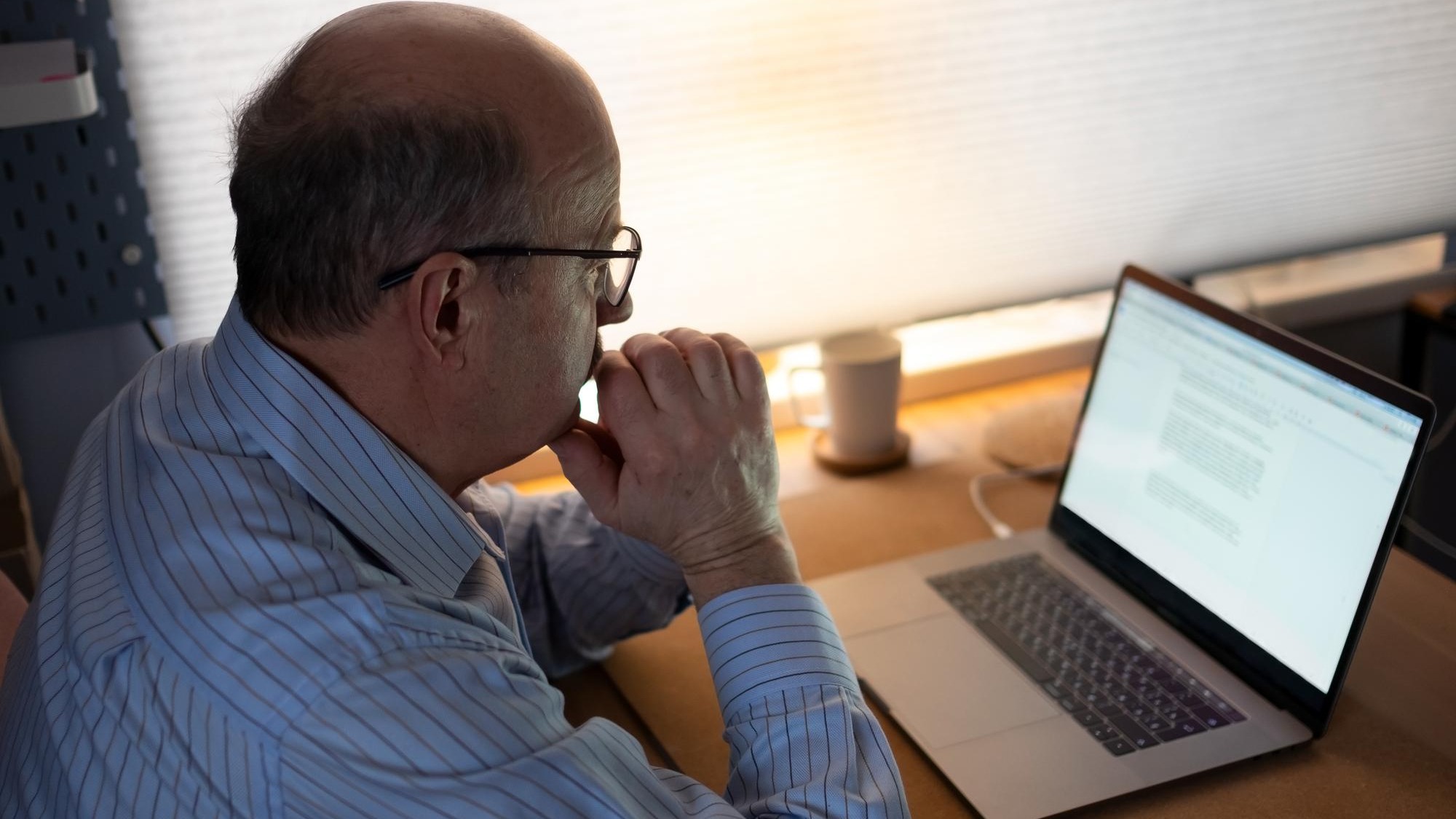 technology, oldness and lifestyle concept. Senior man in eyeglasses working with laptop computer at home and thinking on document.
