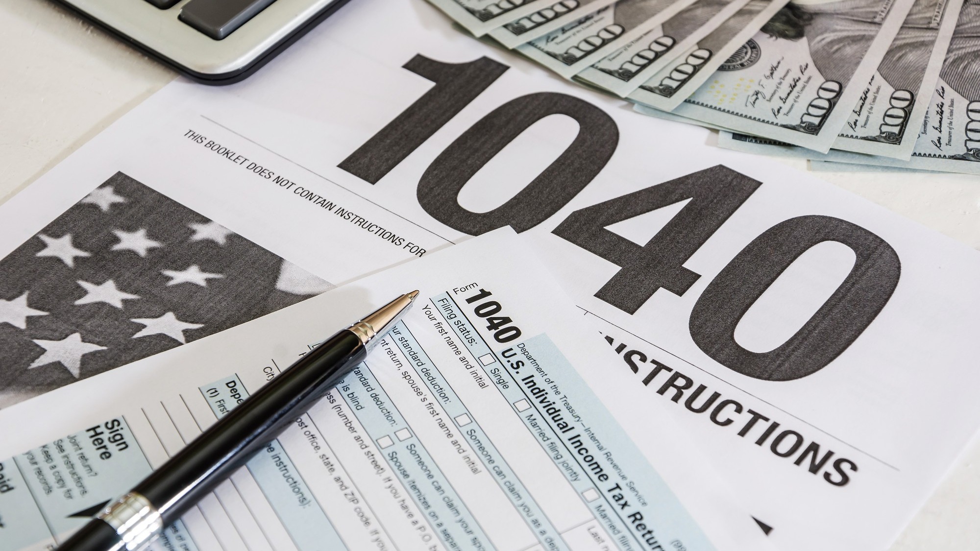 tax forms 1040 and calculator with dollars
