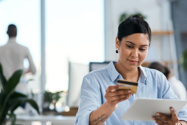 Completing business payments with ease Shot of a young businesswoman using a digital tablet and credit card in an office