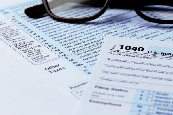 1040 Individual Income Tax Return Form with black rimmed glasses close up
