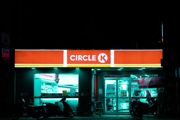 a store front at night with a motorcycle parked in front of it