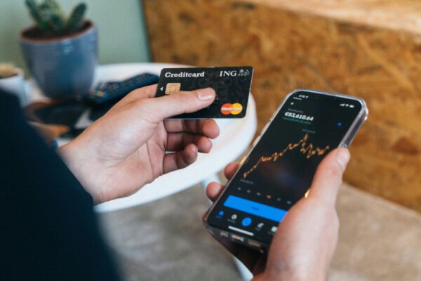 a person holding a smart phone and a credit card