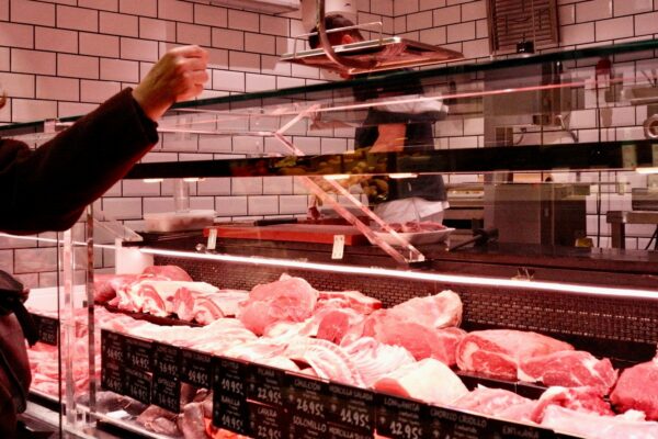 Customer selects raw meat from butcher display case