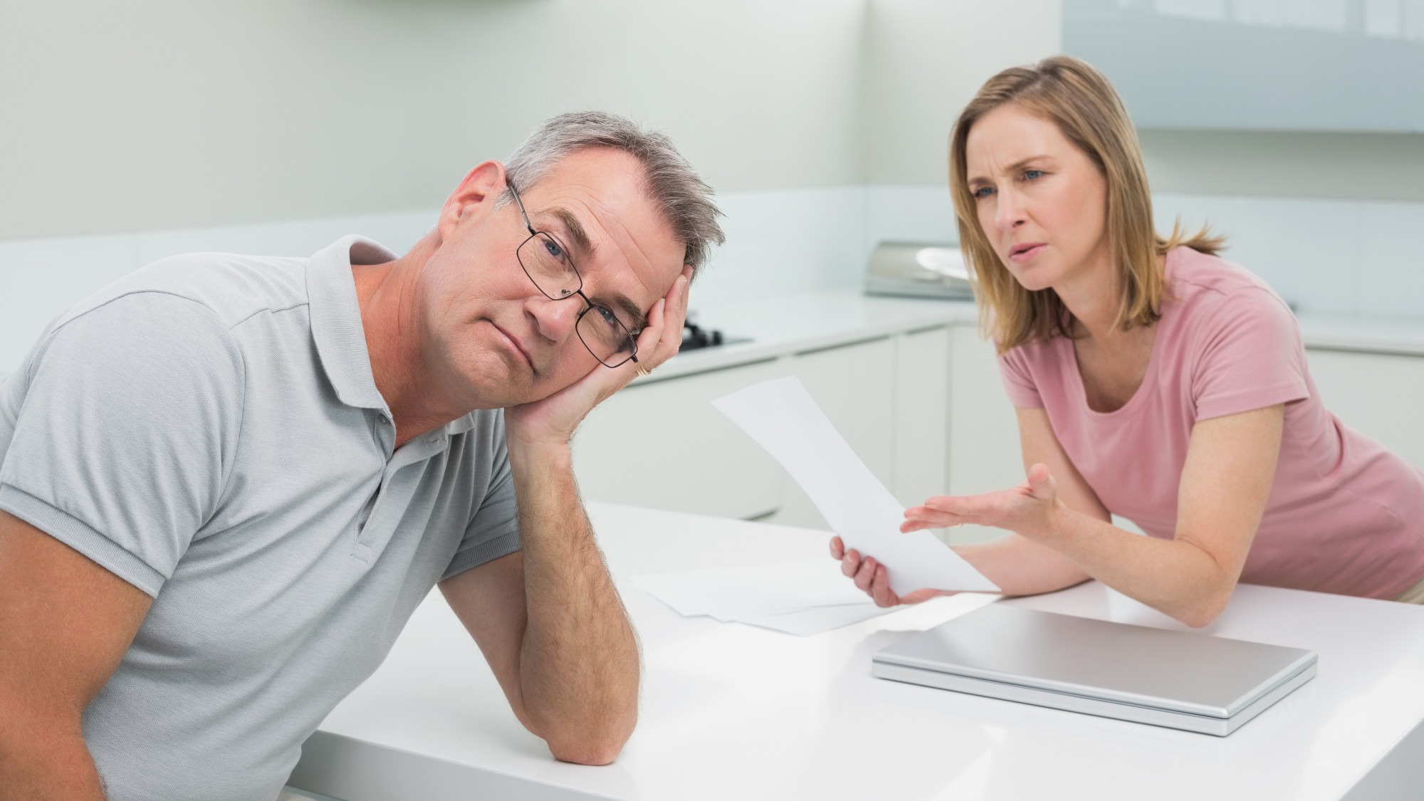 Couple having an argument over a bill in kitchen