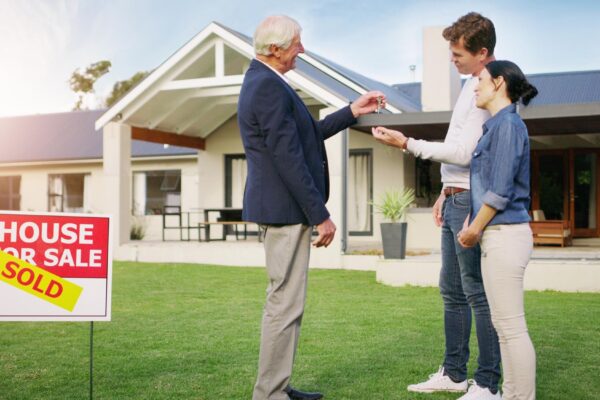 Couple real estate and realtor with keys to new home payment or mortgage loan on lawn outside Happy man and woman in relationship or homeowners with agent for buying property sale or sold house