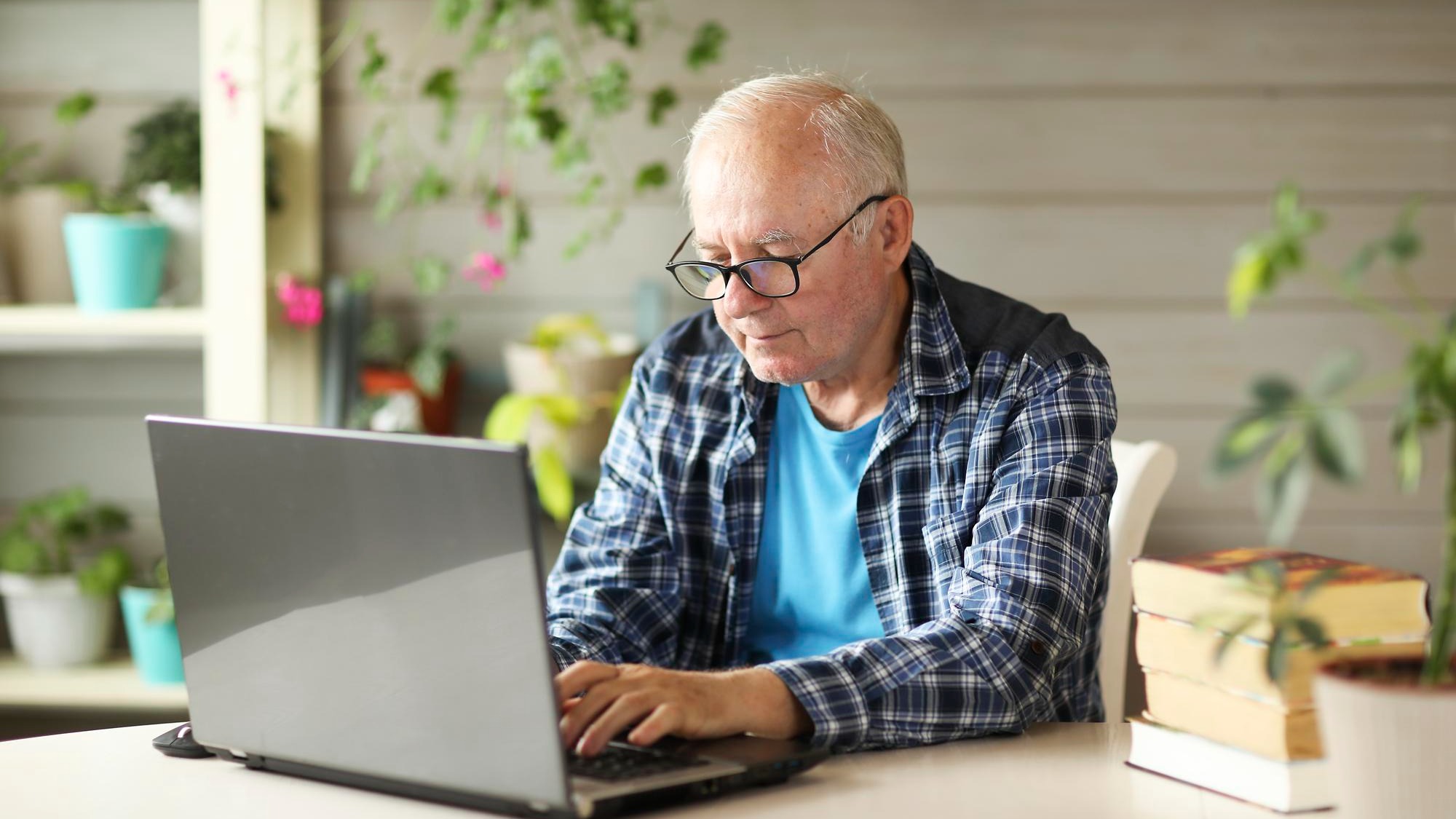 Elderly man working on computer while sitting at home