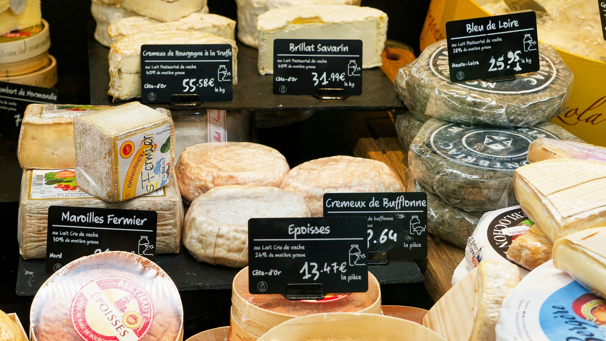 A display case filled with lots of different types of cheese