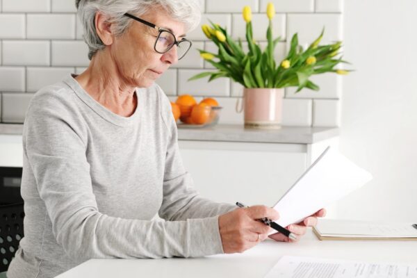 Elderly appealing lady dealing with paperwork and agreements at home