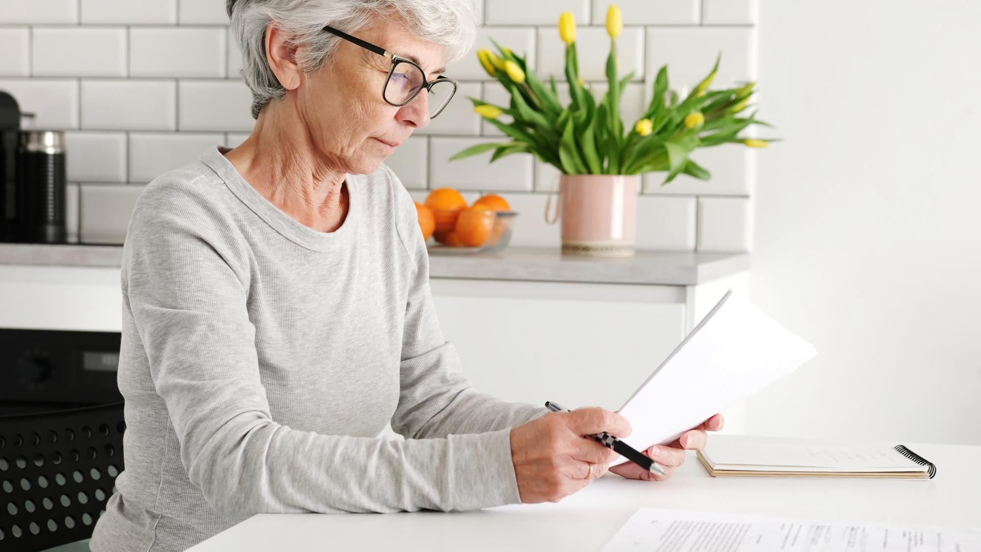 Elderly appealing lady dealing with paperwork and agreements at home