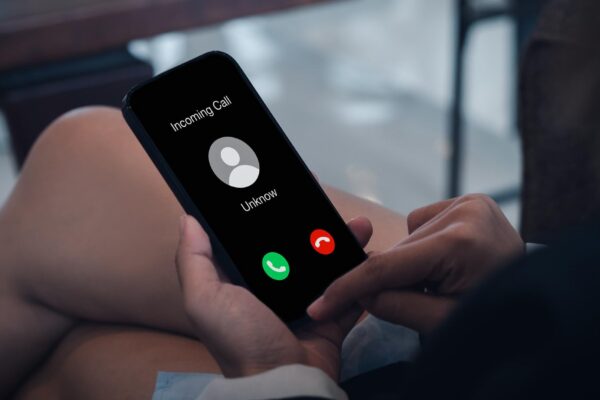 Incoming call with unknown caller malicious phone calls concept Unknown number displayed showing on smart mobile phone in business person hand Spam and robocalls scam call alert