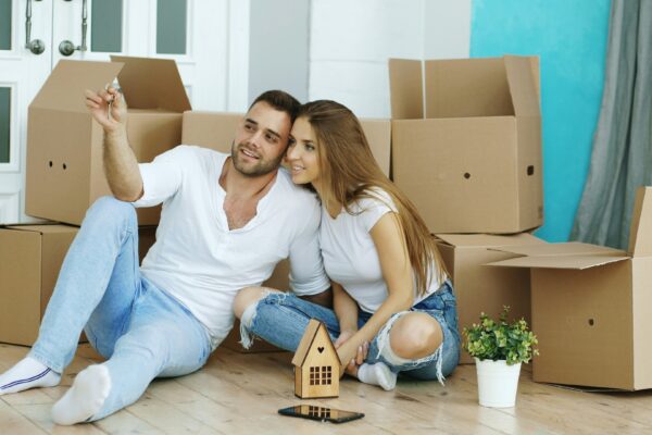 Couple sitting on floor surrounded by moving boxes