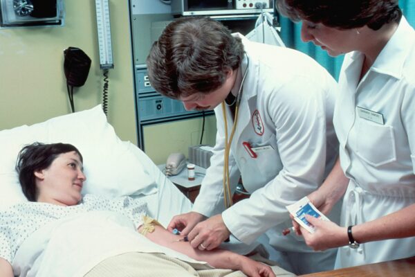 a woman laying in a hospital bed next to a man