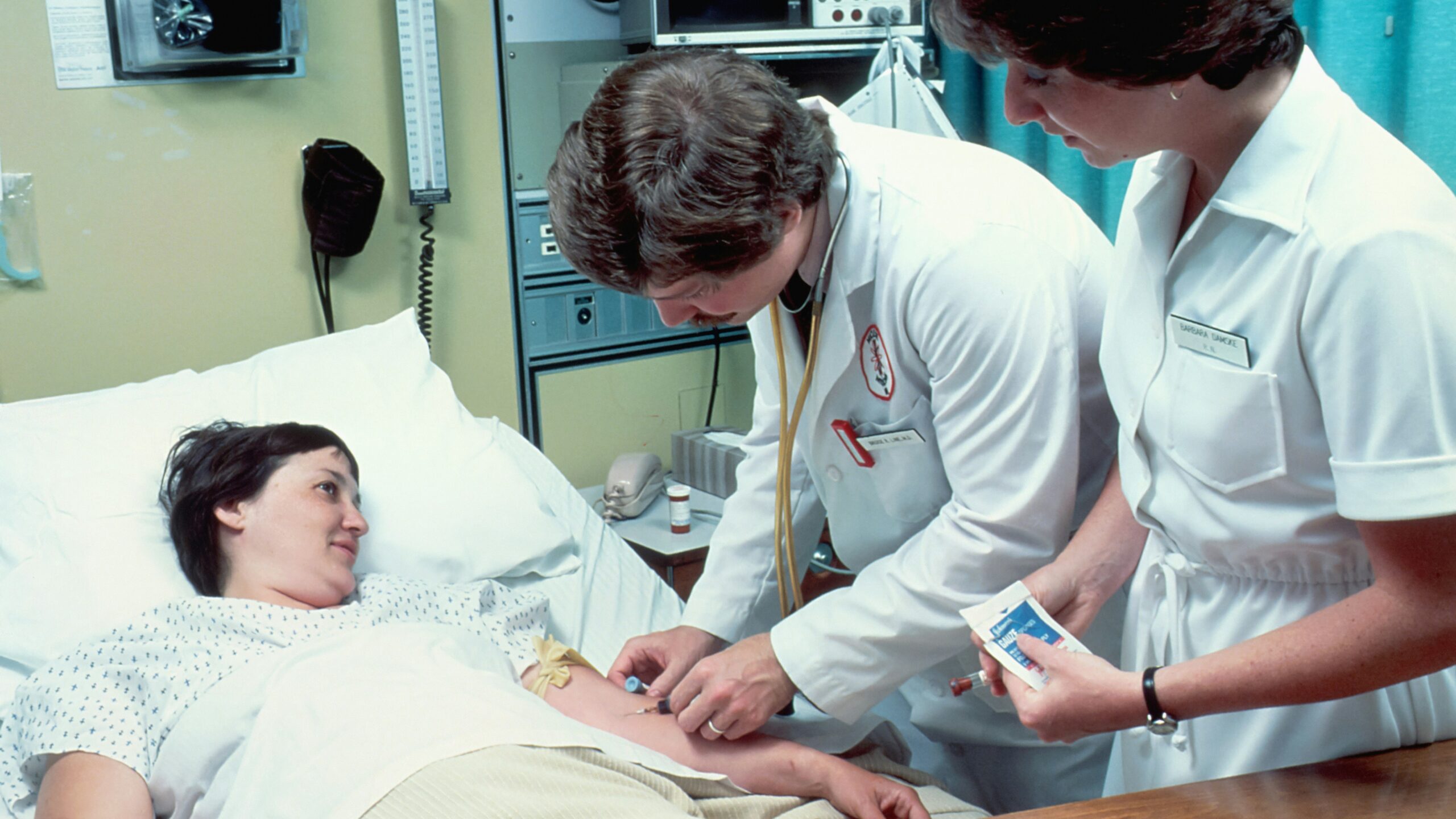a woman laying in a hospital bed next to a man