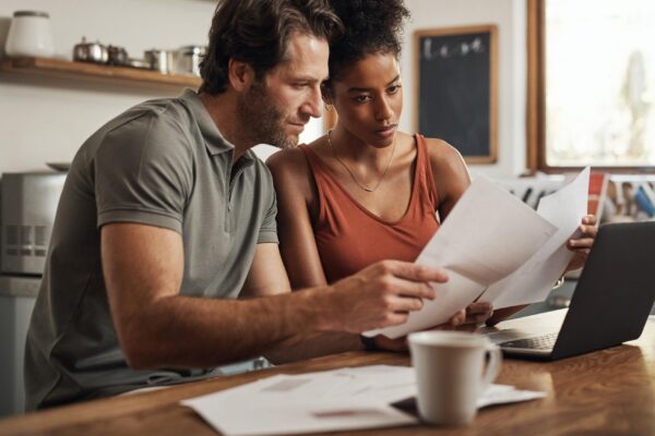 Its never too late to start Cropped shot of a couple using their laptop and going through paperwork at home