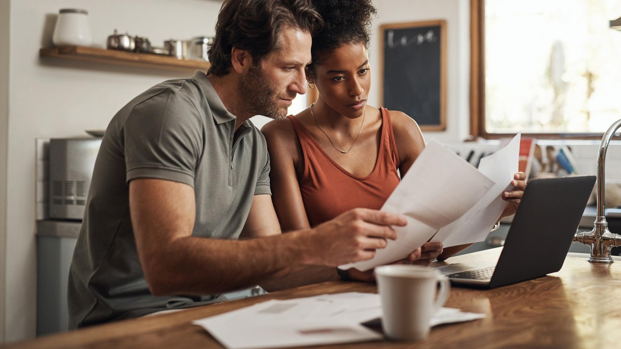 Its never too late to start Cropped shot of a couple using their laptop and going through paperwork at home