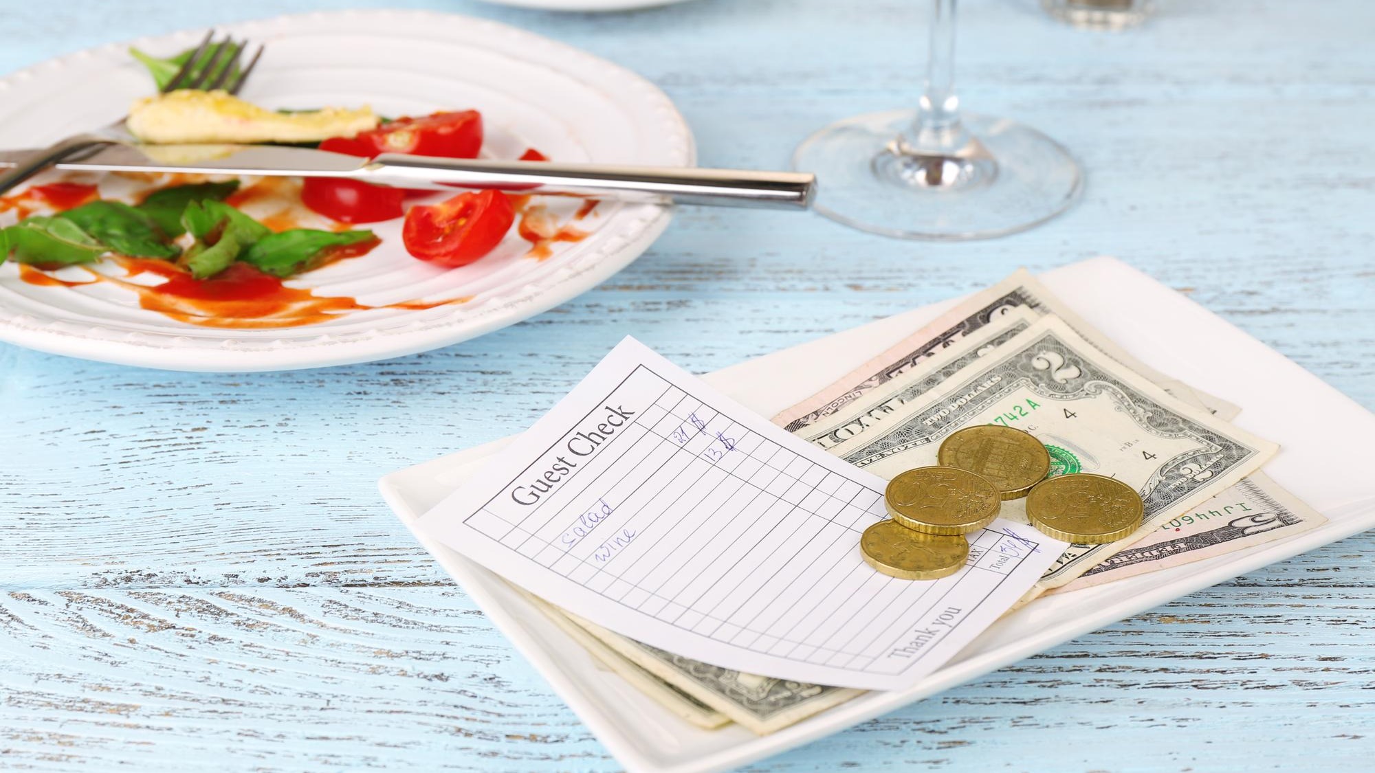 Check and remnants of food on table in restaurant