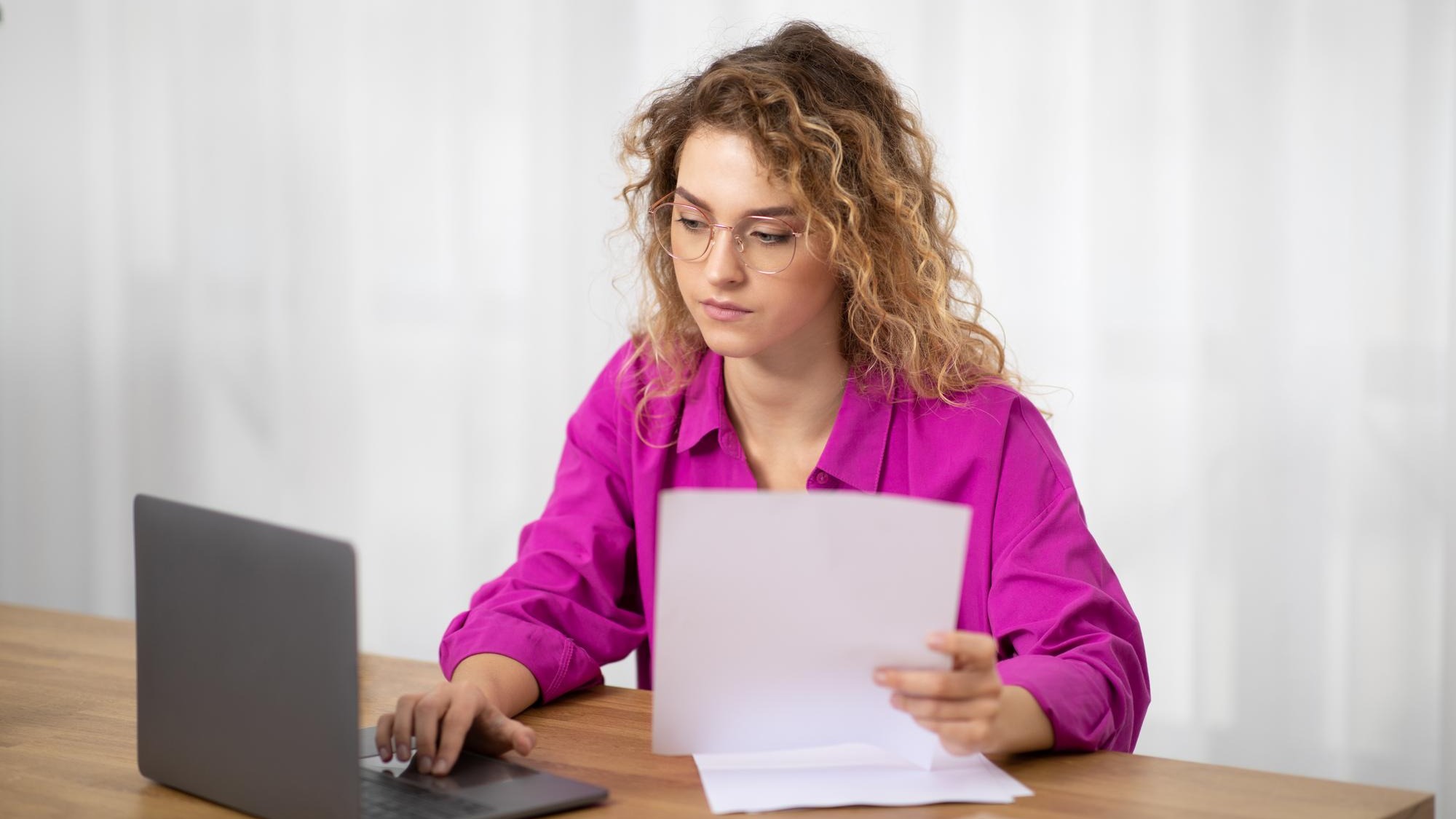 Remote work young woman working with papers and laptop at home office