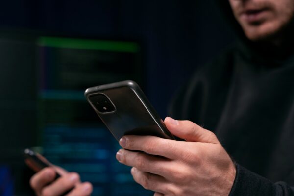 Close up hacker holding smartphone
