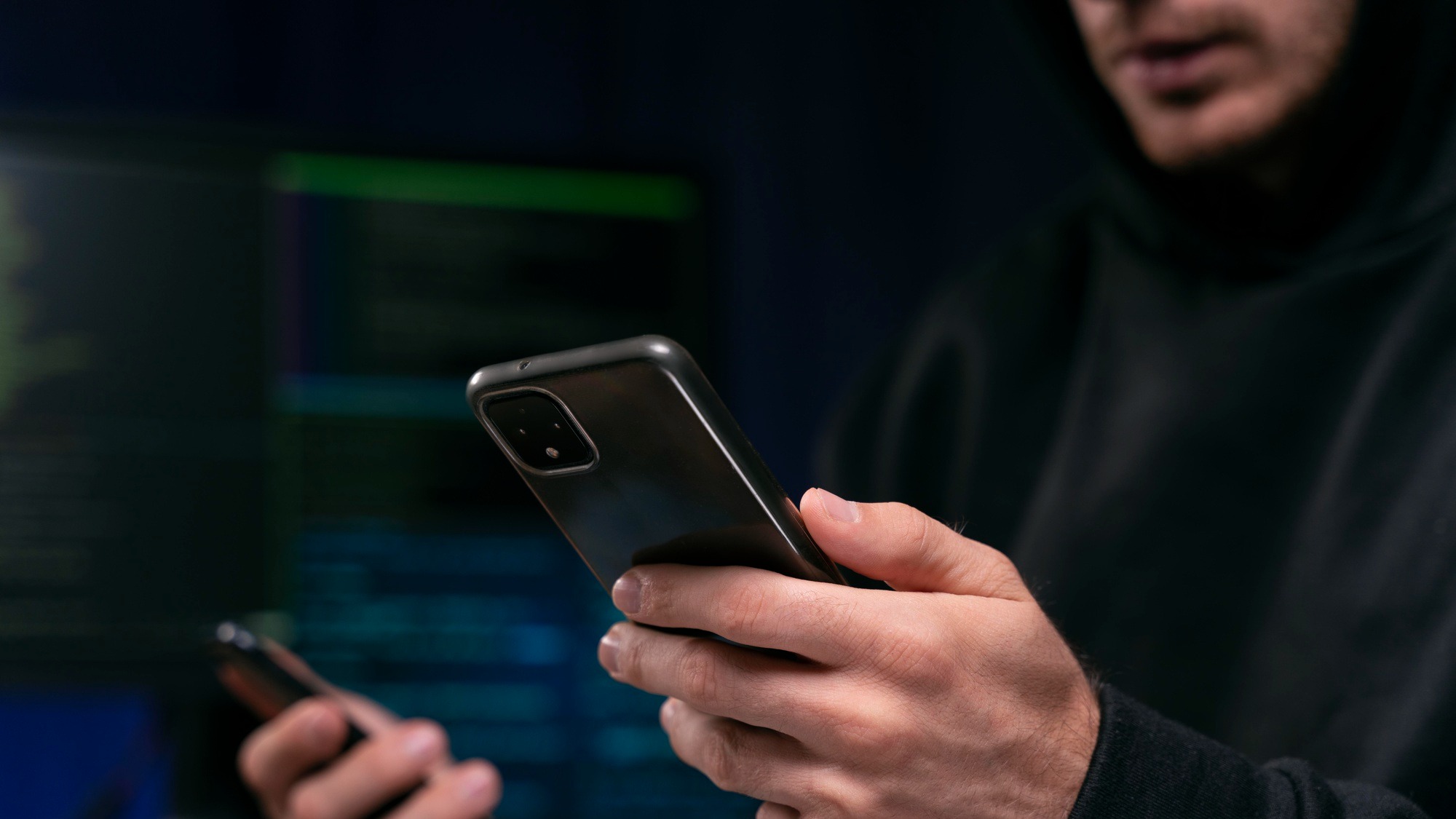 Close up hacker holding smartphone