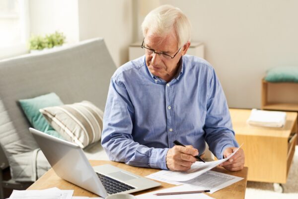 Senior Man Filing Tax Report at Home