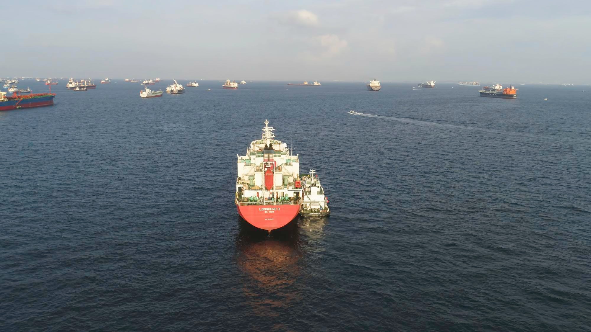 Many cargo ships sailing in the sea in sunny weather on blue sky background shot barges moving in