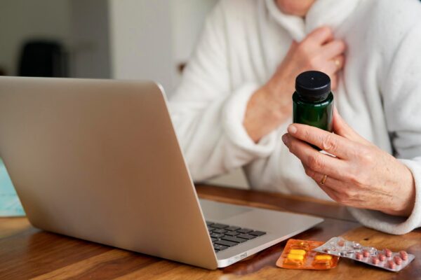 Close up of sick woman consults doctor online using a laptop