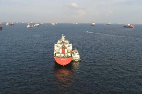 Many cargo ships sailing in the sea in sunny weather on blue sky background shot barges moving in