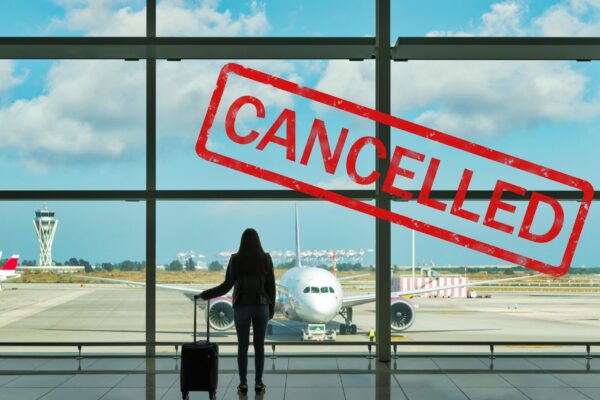 Young woman with suitcase in the departure hall at airport.
