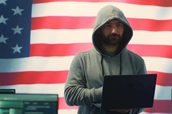 A hacker working in a governmental IT workspace with the USA flag