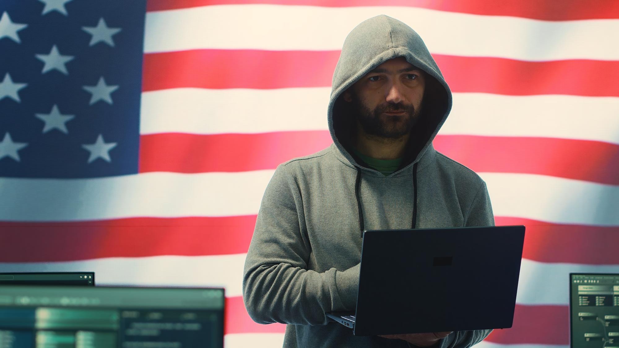 A hacker working in a governmental IT workspace with the USA flag