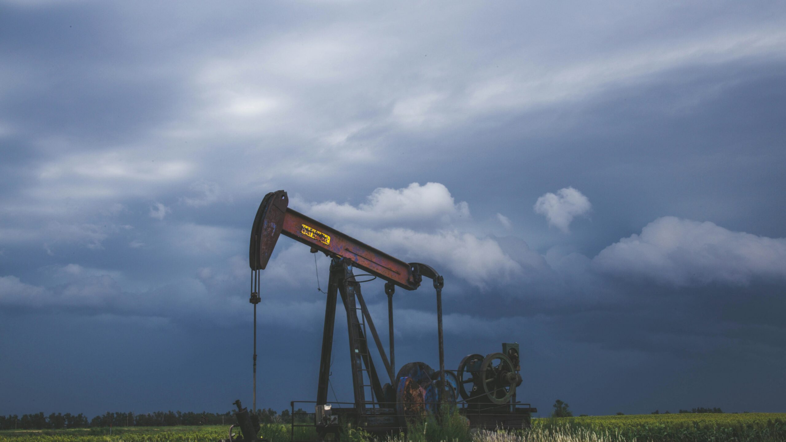 red and black heavy equipment on green grass field under white clouds during daytime
