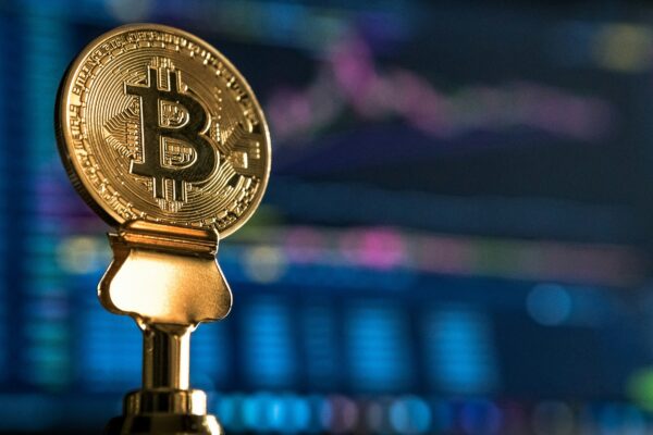 selective focus photo of Bitcoin near monitor